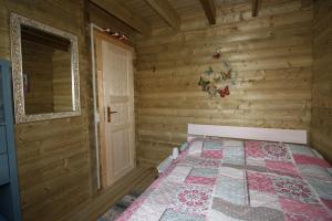 um quarto com uma cama num chalé de madeira em Villa Emilia - Gemütliches kinderfreundliches Blockhaus mit umzäuntem Garten em Sint-Annaland