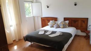 a bedroom with a bed with two slippers on it at Lanui Guest House in Sintra