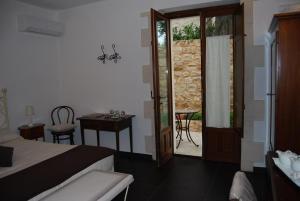 a bedroom with a bed and a table and a door at Silva Suri in Marina di Ragusa