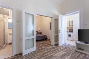 a living room with a bed and a television in a room at Goldcentral Apartment in Budapest