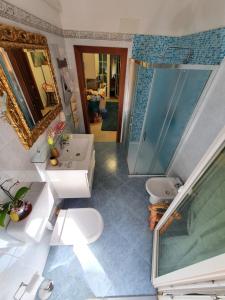 een badkamer met een wastafel, een toilet en een spiegel bij B&B Chez Elisabeth in Padua