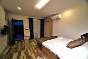 una camera d'albergo con due letti e una televisione di Milyos Hotel a Bucak