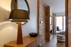 a lamp on a wooden table in a living room at Interlude Megève 4 Stars 2BR Parking & Garden in Megève