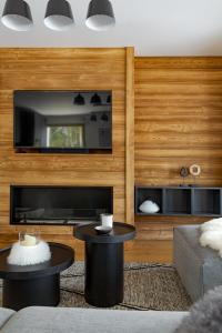 a living room with two tables and a fireplace at Interlude Megève 4 Stars 2BR Parking & Garden in Megève +19 photos
