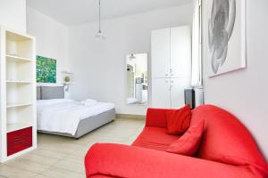 a living room with a red couch and a bed at Aurora Residence in Gela