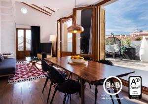 een eetkamer met een houten tafel en stoelen bij B&B Apartamentos Madrid Centro Fuencarral 46 in Madrid