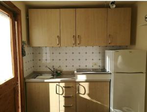 a kitchen with wooden cabinets and a white refrigerator at Sentieri Sul Mare in Manarola