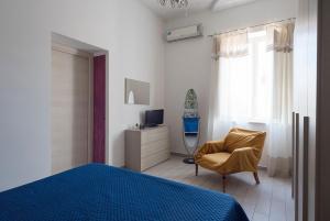 ナポリにあるAppartamento Alexのベッドルーム(ベッド1台、椅子、テレビ付)