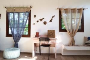 a room with a desk and two windows at La Casa Encantada del Bosque in Icod de los Vinos