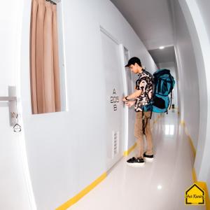 a man with a backpack is walking down a hallway at AUR KUNING HOSTEL SYARIAH Bukittinggi in Bukittinggi