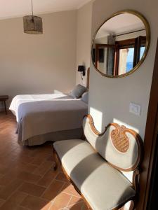 a bedroom with two beds and a mirror and a chair at Vitabella Toscana in Seggiano