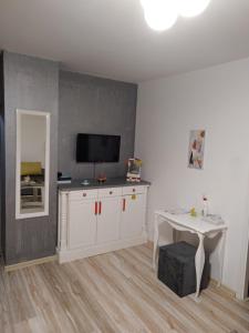 Sala de estar con armario blanco y TV en Happy M&S, en Šabac