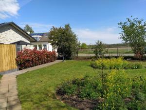 una casa con un patio con césped y flores en De Kuiperij, en Arcen