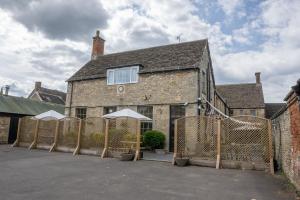 an old brick building with a fence in front of it at White Hart Hotel in Cricklade