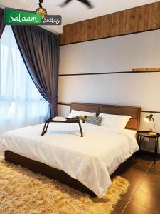 sypialnia z dużym łóżkiem z białą narzutą w obiekcie Troika Kota Bharu by Salaam Suites w mieście Kota Bharu