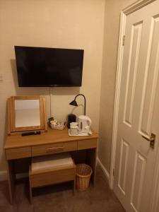 a room with a desk with a television and a mirror at Beach Cove in Llandudno