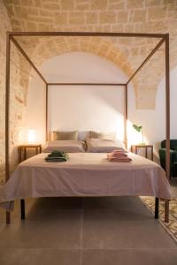 1 dormitorio con cama con dosel en una habitación en La Casa di Agata, en Ceglie Messapica