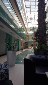 a large lobby with a swimming pool with plants at Diva Capitol Luxury in Skopje