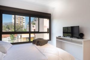 1 dormitorio con 1 cama y TV de pantalla plana en Apartamento Rua Casemiro de Abreu, 199, en Porto Alegre