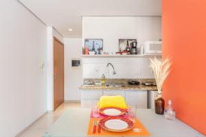 uma pequena cozinha com uma mesa e uma cadeira amarela em Apartamento Rua Casemiro de Abreu, 199 em Porto Alegre