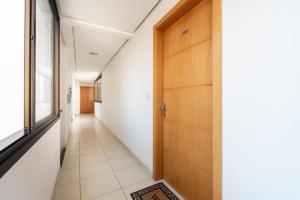 a hallway with a wooden door and a tile floor at Apartamento Rua Casemiro de Abreu, 199 in Porto Alegre