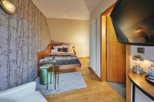 um quarto com uma cama e uma televisão num quarto em Boutiquehotel Liebesglück - adults only em Winterberg