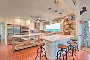a kitchen with a large island with bar stools at Spacious Getaway about 12 Acres, Views, and Hot Tub! in Strawn