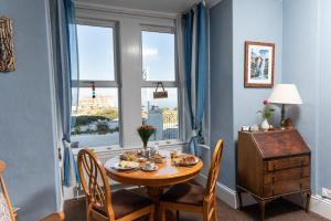 a dining room with a table and chairs and a window at Bosayne Guest House in Tintagel