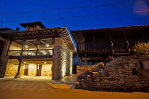 a building with a balcony and a stone wall at Los Campos Vivienda Vacacional in Cangas de Onís