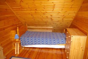 pokój z łóżkiem w drewnianym domku w obiekcie Chalet de 3 chambres avec jardin amenage et wifi a Basse sur le Rupt w mieście Basse-sur-le-Rupt