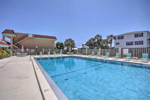 une piscine avec des chaises et un bâtiment dans l'établissement Coastal Getaway with Porch 1 Block to Beach!, à Saint Augustine