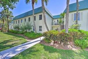 una casa blanca con palmeras y una acera en Naples Condo with Enclosed Balcony and Lake Views!, en Naples