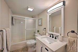 Un baño con lavabo, inodoro y espejo. en Naples Condo with Enclosed Balcony and Lake Views!, en Naples 18 fotos más