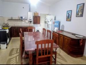 a kitchen with a wooden table and wooden chairs at Casa a 5 km de Villa de Las Rosas in Las Tapias