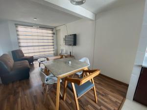 ein Wohnzimmer mit einem Tisch, Stühlen und einem Sofa in der Unterkunft Bonito departamento frente a metro cuatro caminos in Mexiko-Stadt