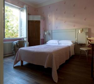 a bedroom with a bed with a white bedspread and a window at Villa Saint Hubert in Nice