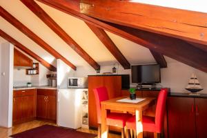 a kitchen with a wooden table and red chairs at Villa Odak in Dubrovnik