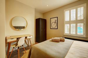 a bedroom with a bed and a desk and a mirror at 60 Manchester Road in Altrincham