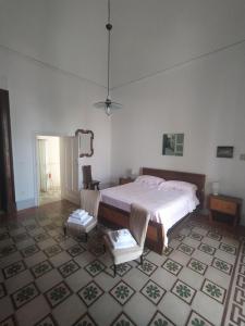 1 dormitorio con cama y alfombra en Donna Bianca B&B, en Specchia