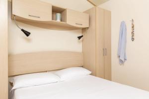 sypialnia z łóżkiem z drewnianym zagłówkiem w obiekcie Comfort Lodge Principina w mieście Grosseto