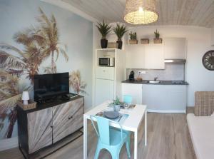 a kitchen and a living room with a table and chairs at Nos Îles in Saint-Jean-de-Monts