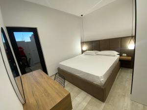 1 dormitorio con cama, mesa y espejo en White Beach Villa 2 - Luxury, en Velipojë