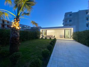 una palma nel cortile di una casa di White Beach Villa 2 - Luxury a Velipojë