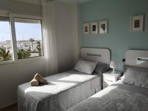 1 dormitorio con 2 camas y ventana en El Remanso III, en La Manga del Mar Menor