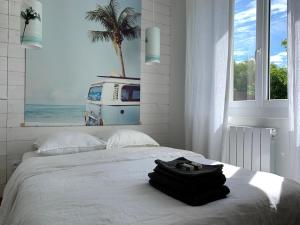 a white bedroom with a bed with a palm tree at Nos Îles in Saint-Jean-de-Monts