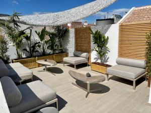a patio with couches and tables and plants at Hostal El Caprichito Marbella in Marbella +25 photos