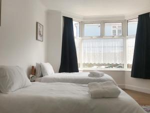 2 camas num quarto com uma janela em Cosy Old House Free Parking Close To Town & Beach em Bournemouth
