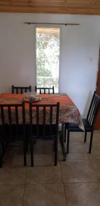 uma mesa de jantar com 2 cadeiras e uma janela em Doña Isabel em Porto Iguaçu