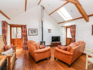 a living room with two chairs and a fireplace at Blueberry Cottage in Haverfordwest