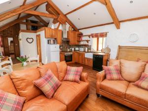 uma sala de estar com dois sofás e uma cozinha em Blueberry Cottage em Haverfordwest